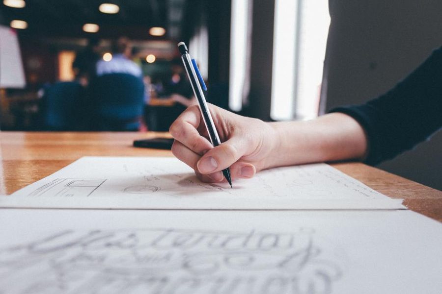 A hand writing carefully on a sheet of paper