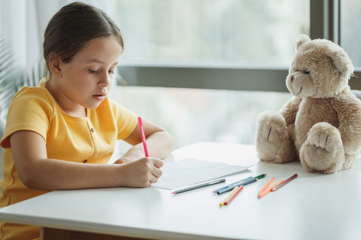 A young child working through a writing exercise at a table