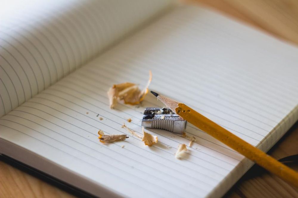 An open notebook with a pencil and sharpener shavings